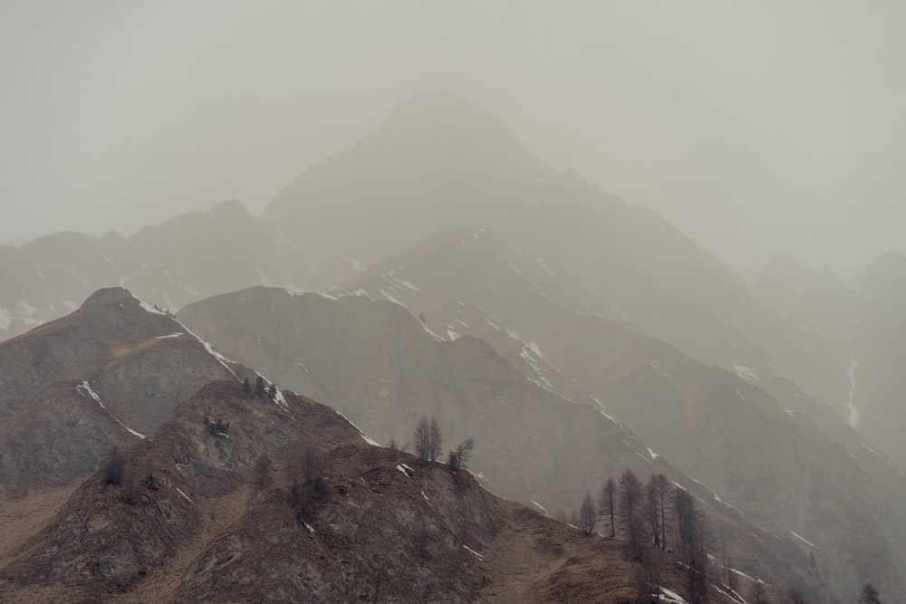a mountain range covered in snow and fog
