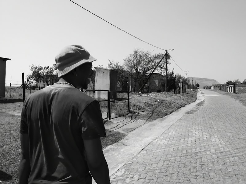 A man walking down a brick road in a South African village