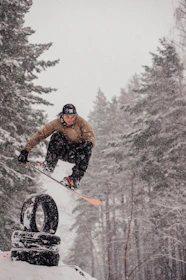 Group of young snowboarders learning tricks on boxes and jumps.