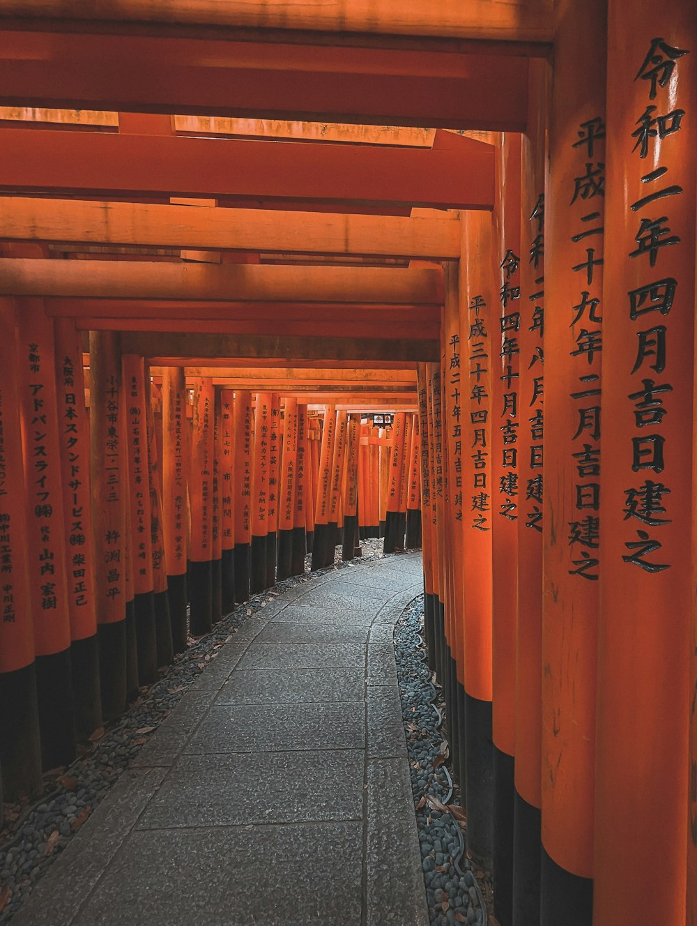 a walkway lined with lots of orange pillars