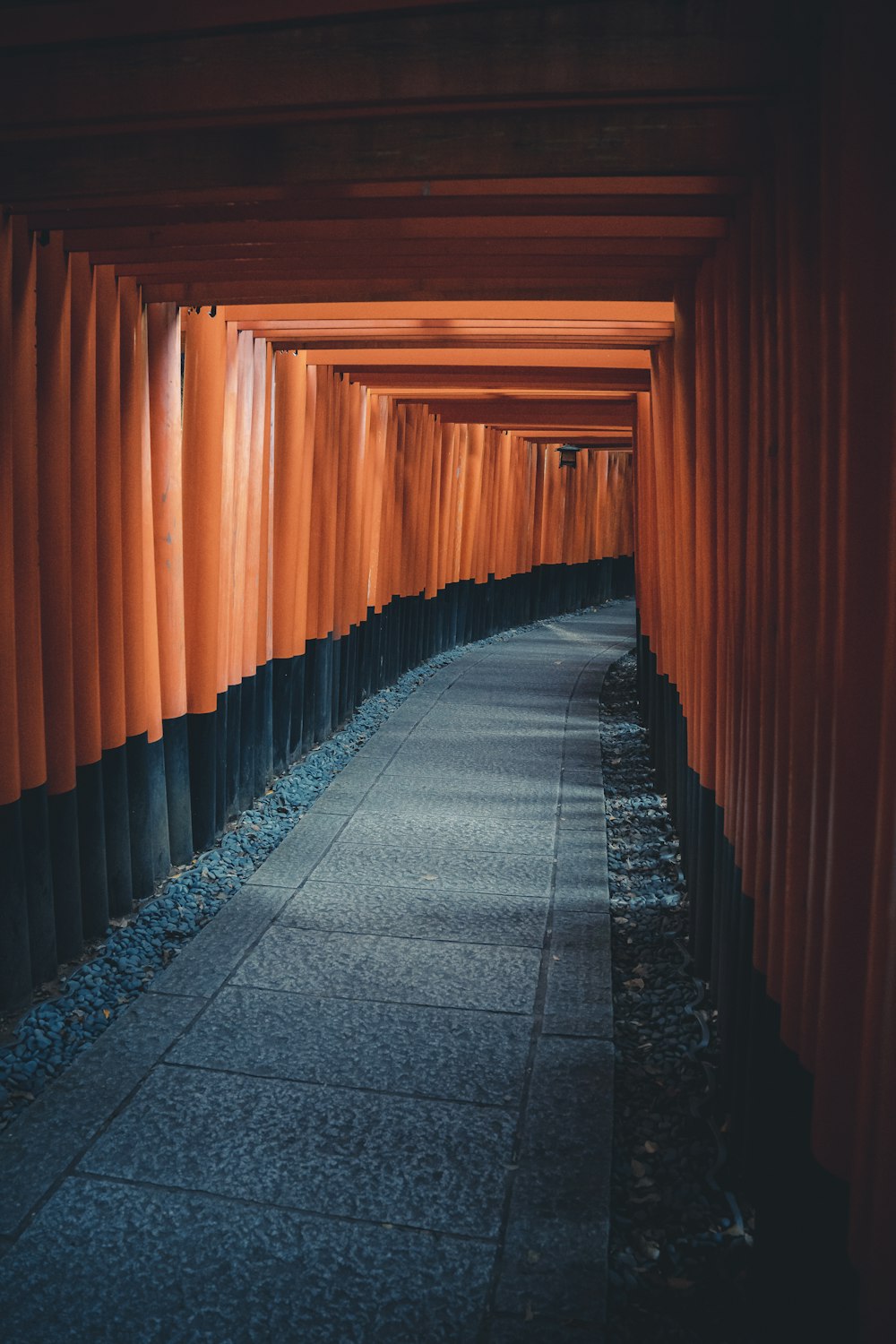 a walkway lined with orange and black columns