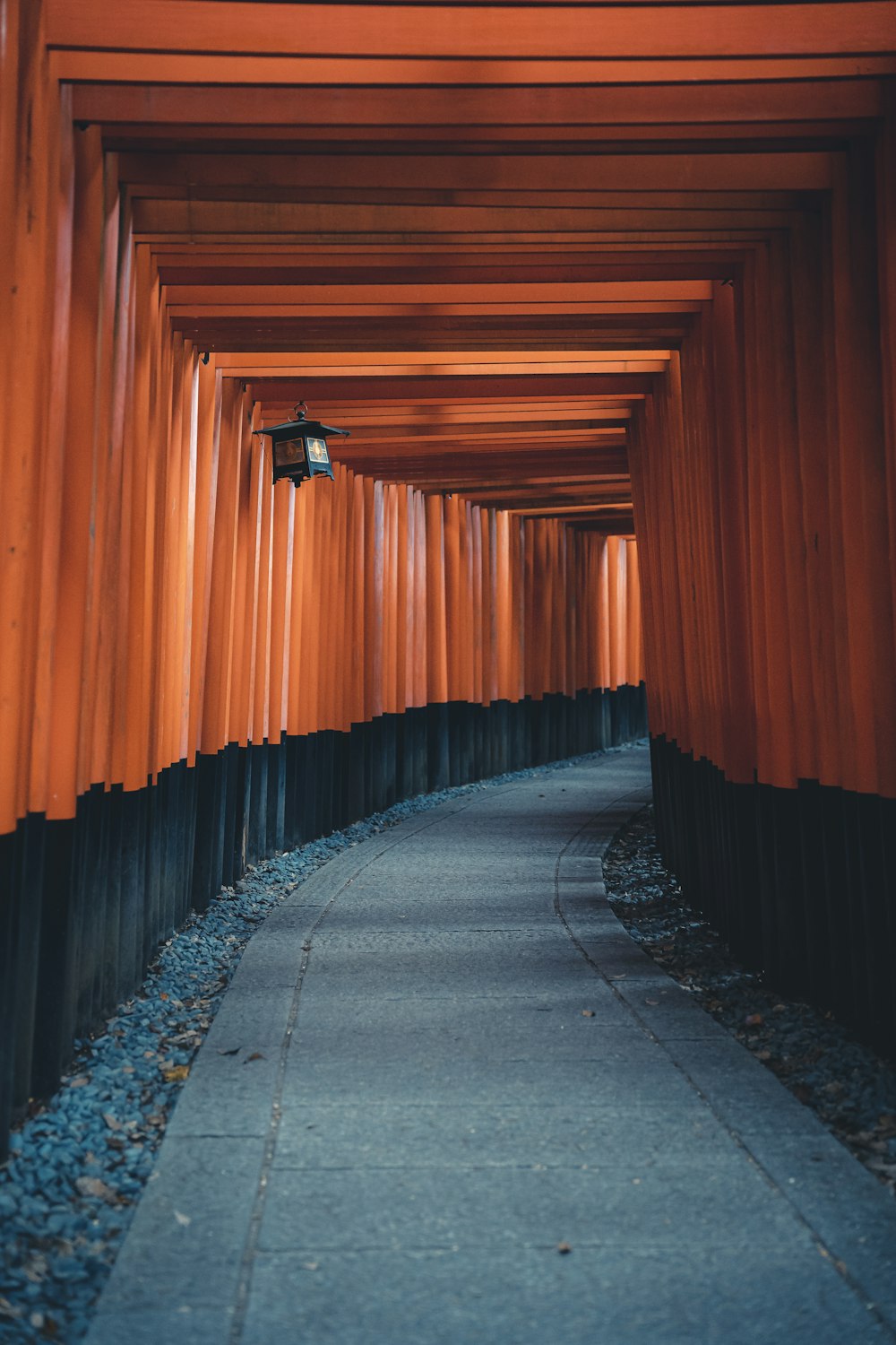 a long walkway lined with orange wooden pillars