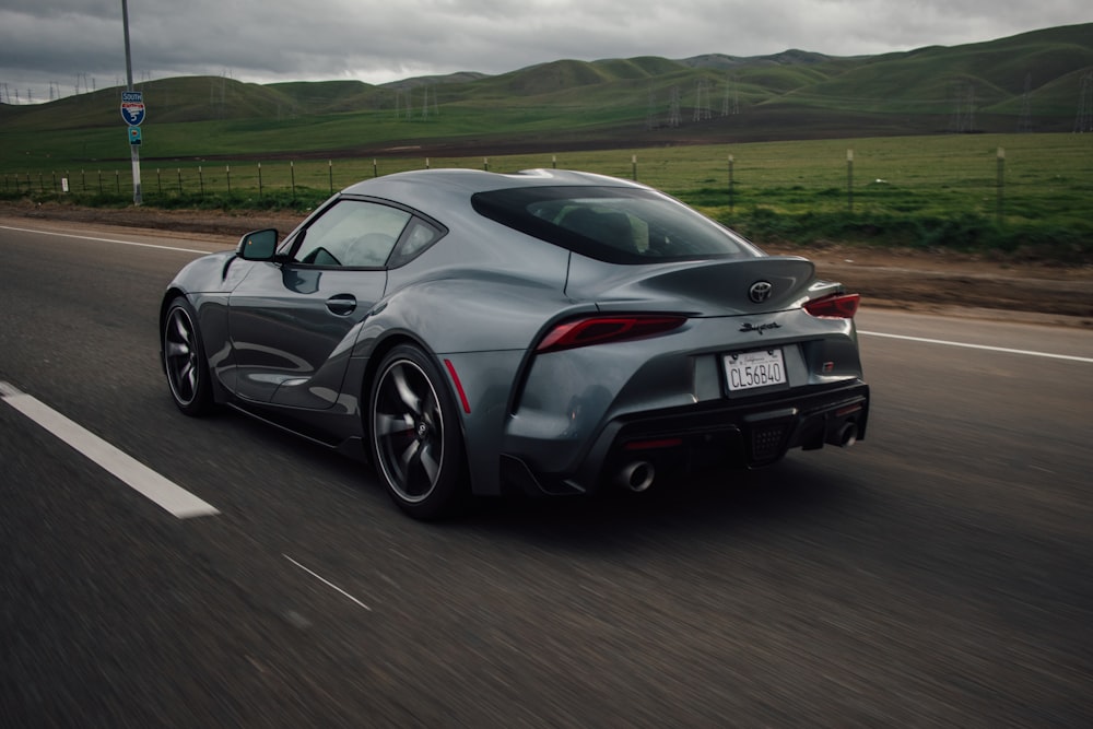 a gray sports car driving down the road