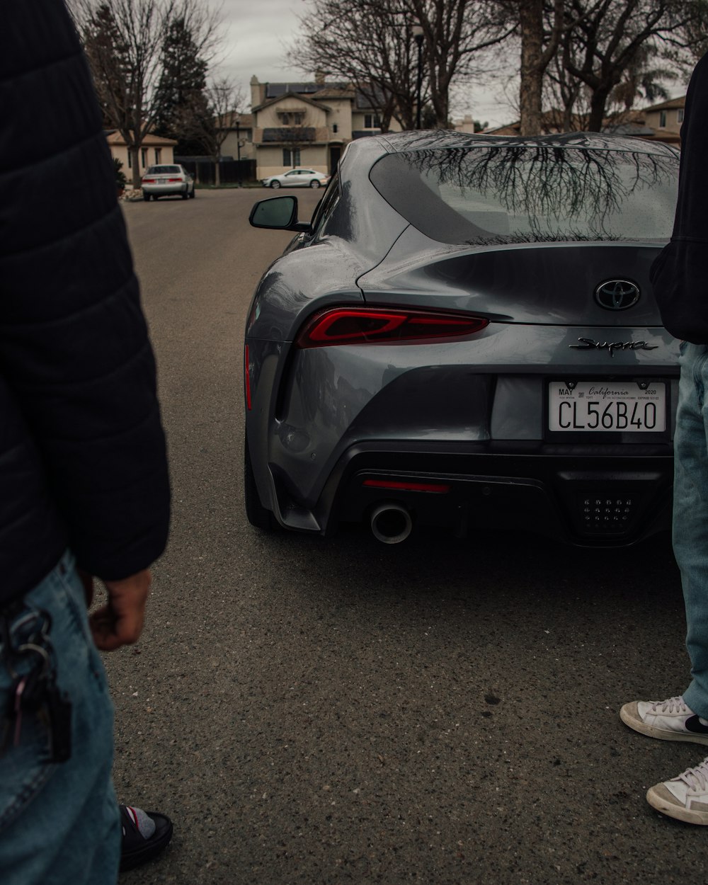 a person standing next to a car on a street