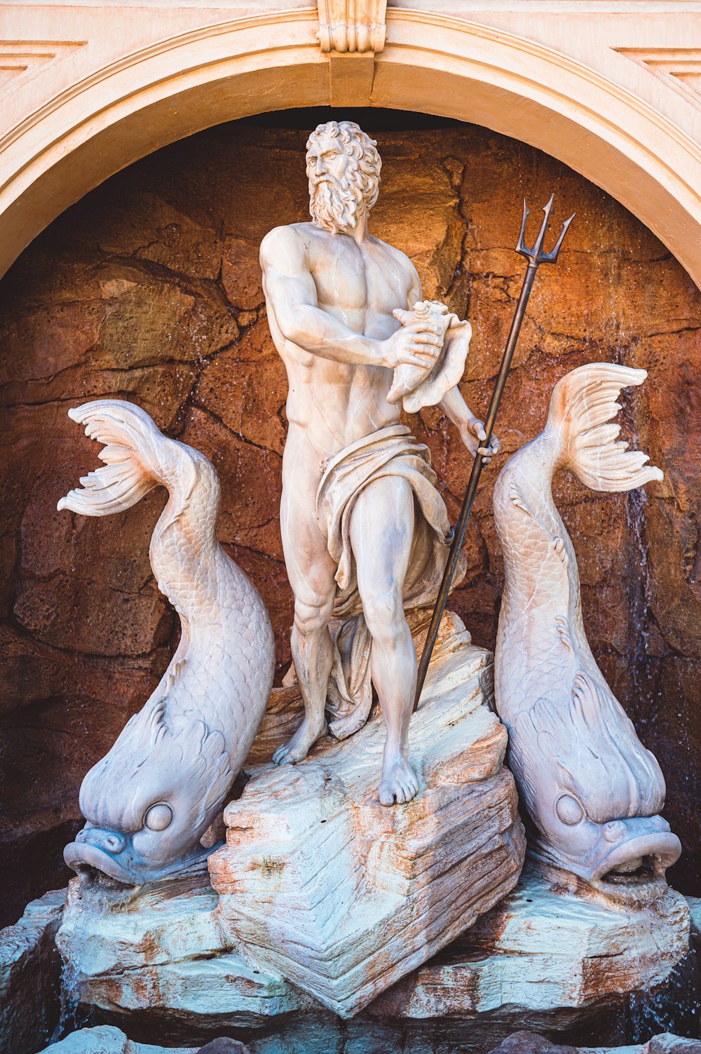 a statue of a man with a spear and two seagulls