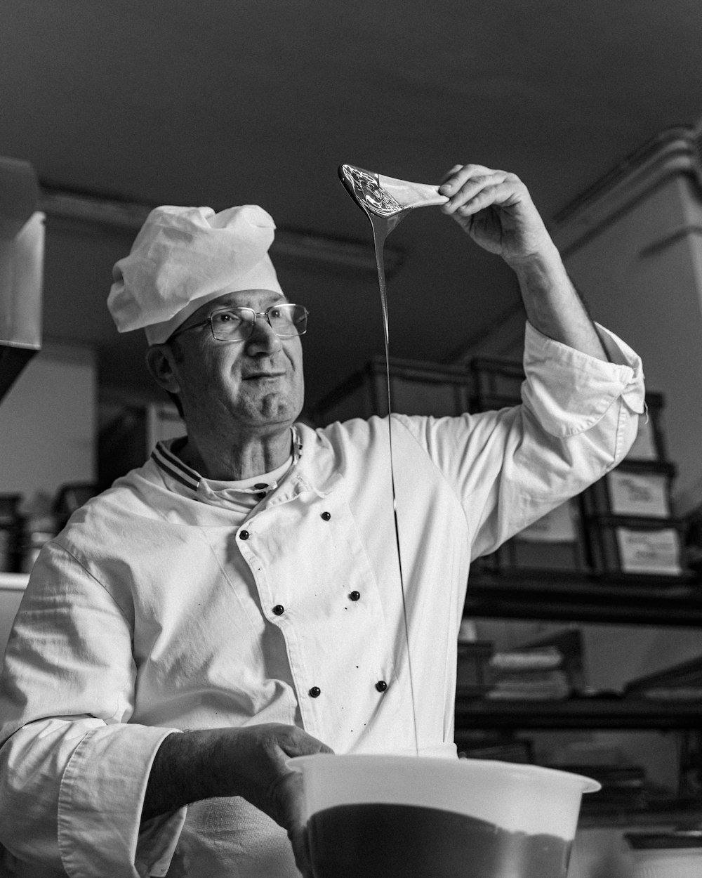 a man in a chef's uniform holding a spoon
