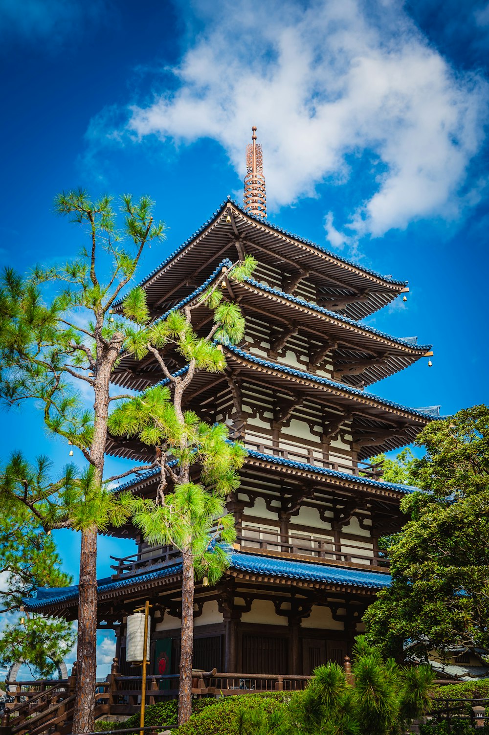 a tall building with a blue roof surrounded by trees