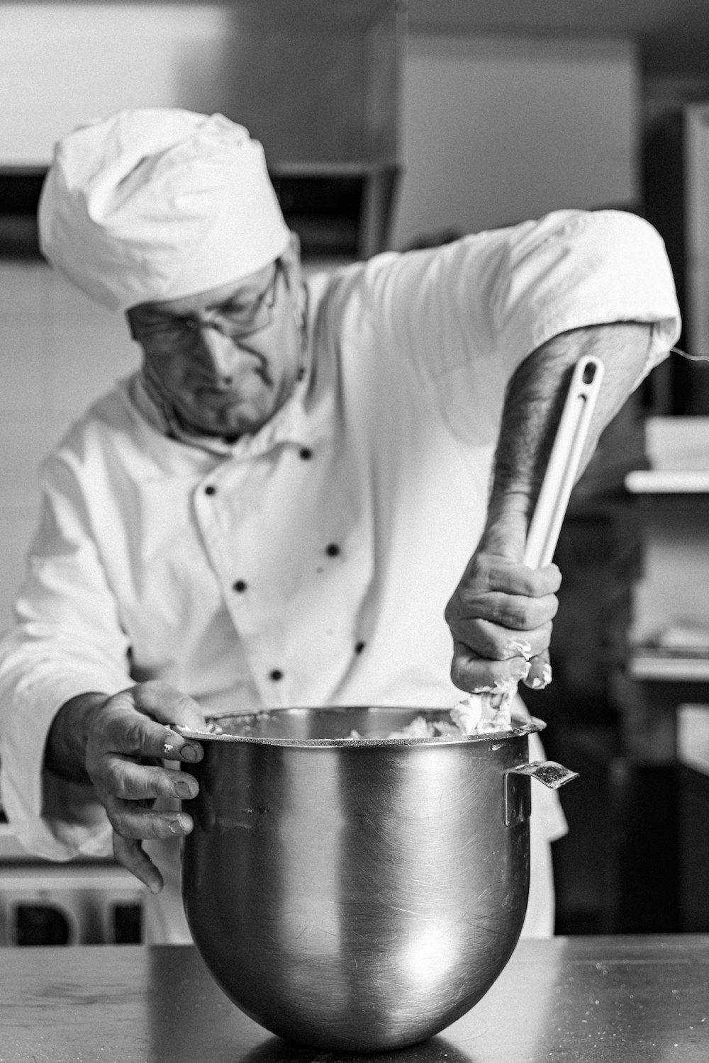 a black and white photo of a chef in a kitchen