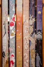 a bunch of different colored sashes hanging on a wall