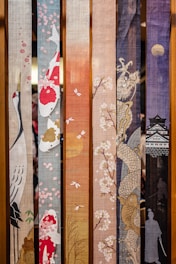 a bunch of different colored sashes hanging on a wall