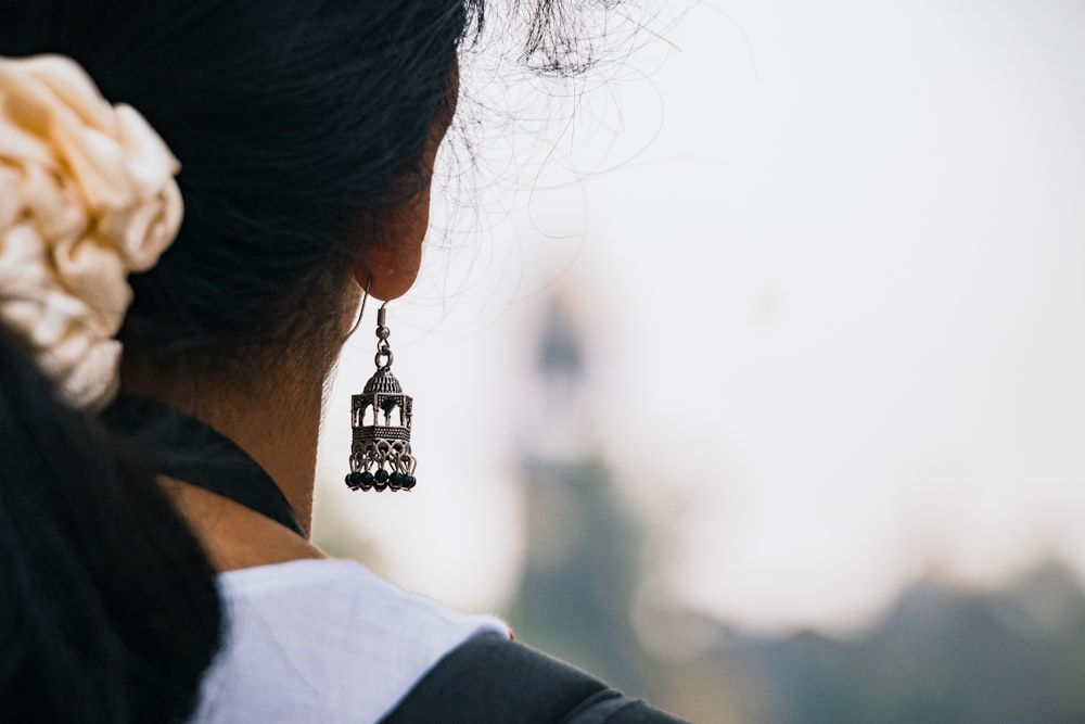 a close up of a person wearing a pair of earrings