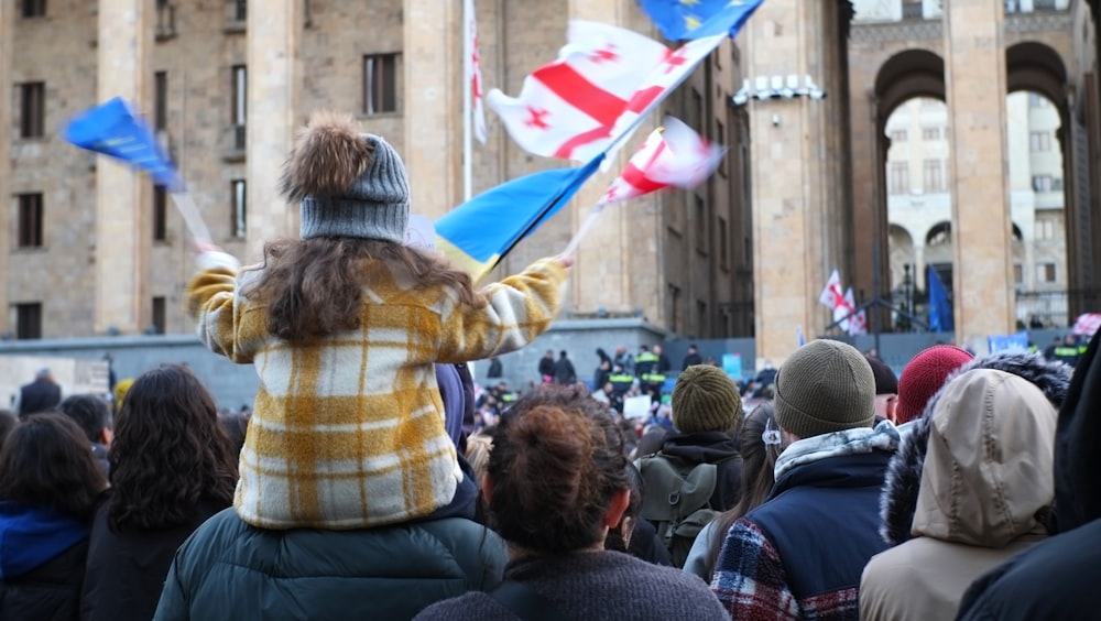 a woman holding a flag in front of a crowd of people