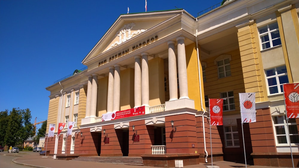 a building with columns and flags on the front of it