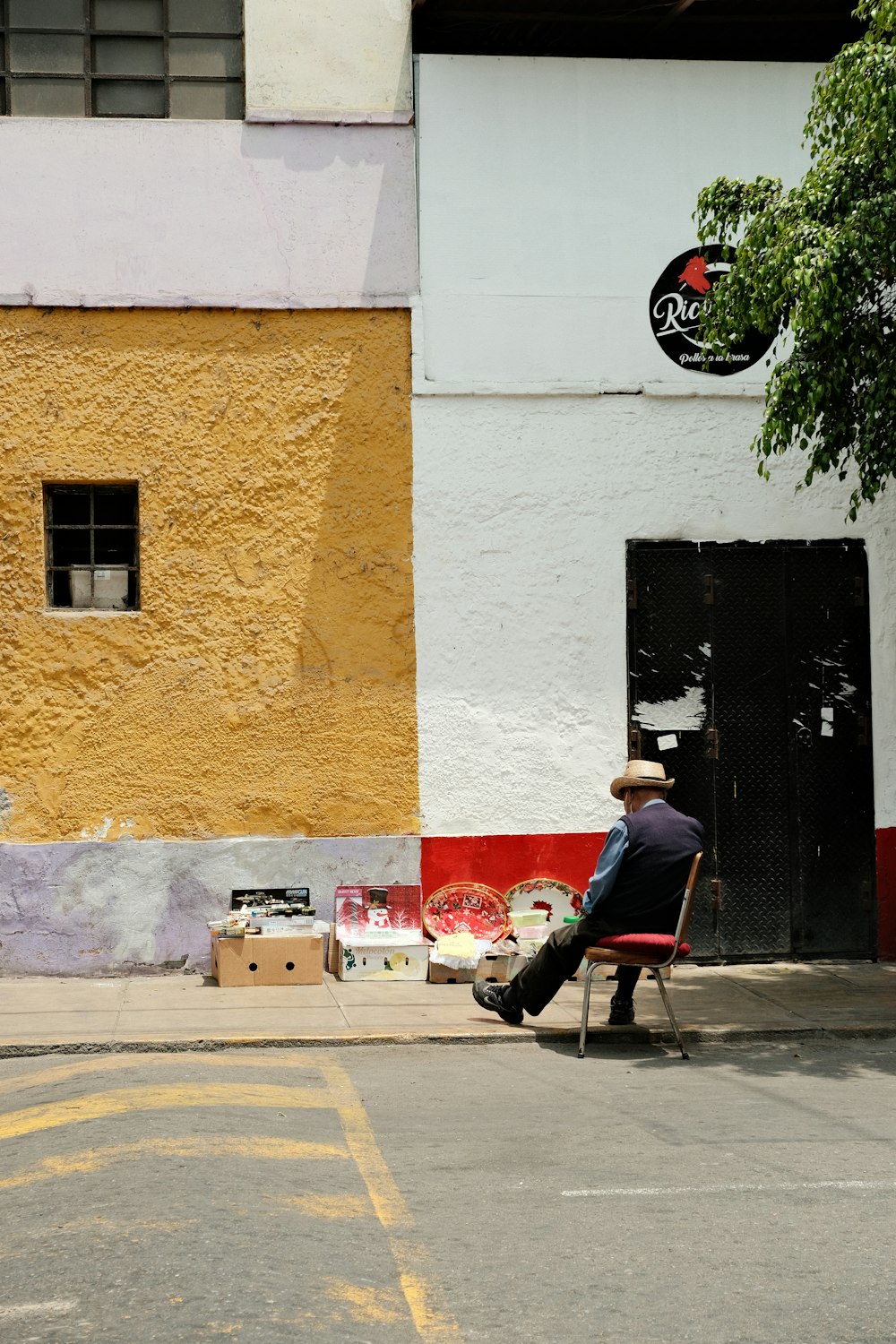 a man sitting on a bench in front of a building