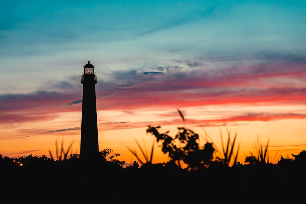 a tall light house sitting in the middle of a field