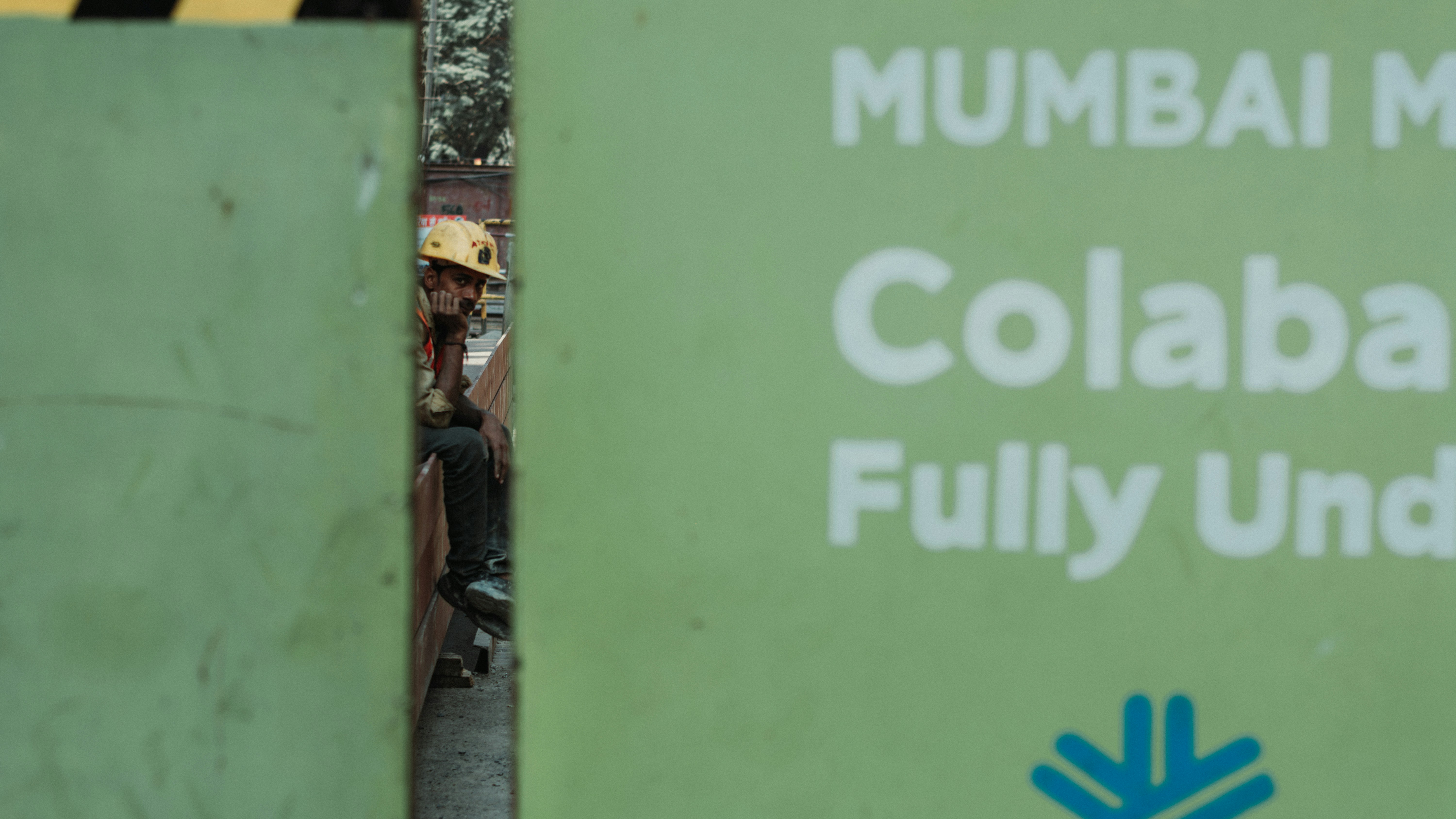 a green sign that says mumbai collabable fully under