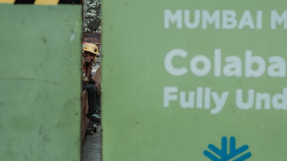 a green sign that says mumbai collabable fully under