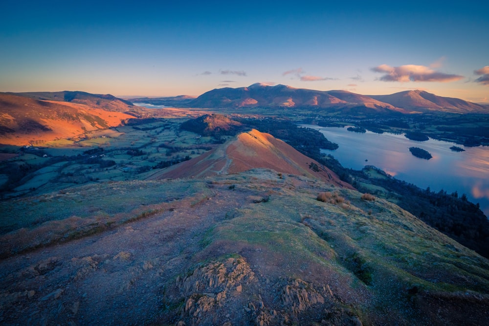 a scenic view of a lake and mountains at sunset