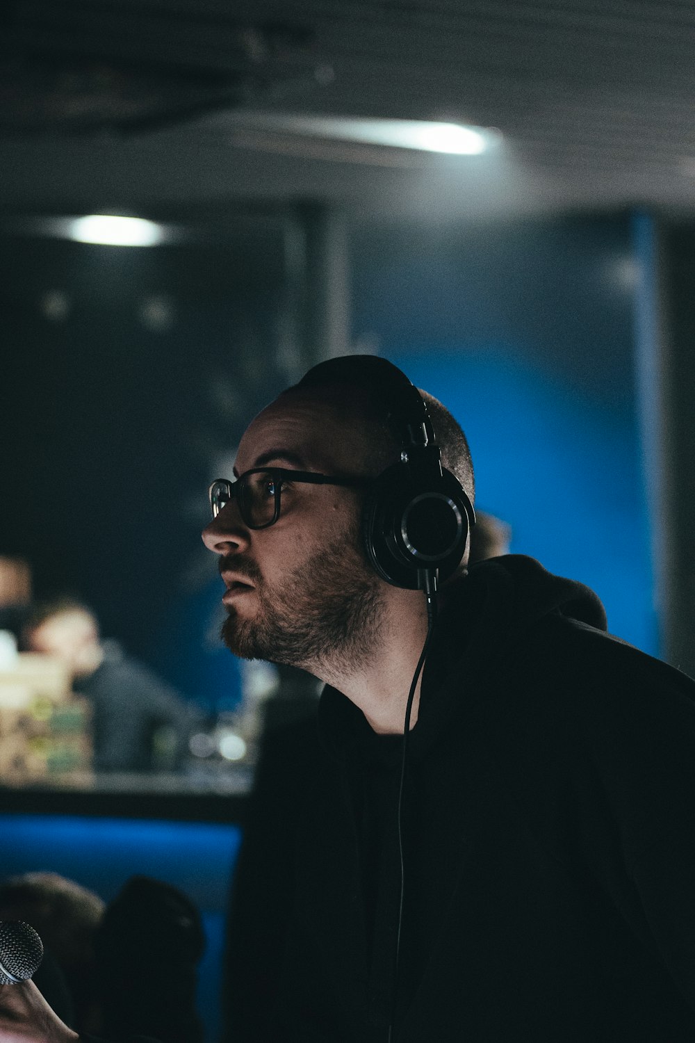 a man wearing headphones sitting in front of a microphone