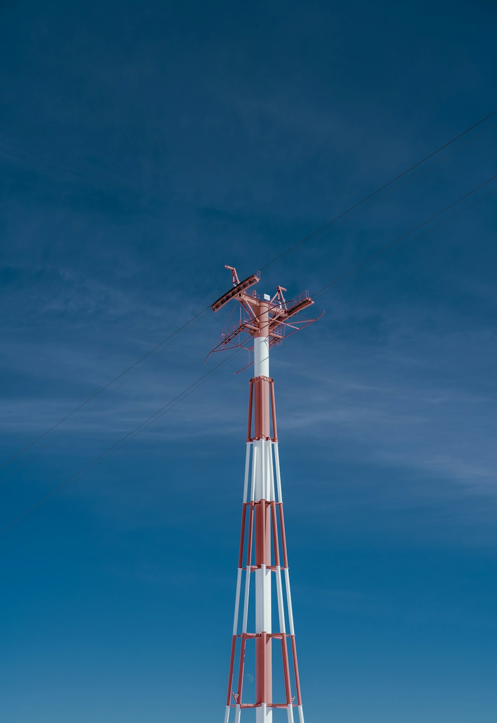 a tall red and white tower sitting on top of a snow covered field