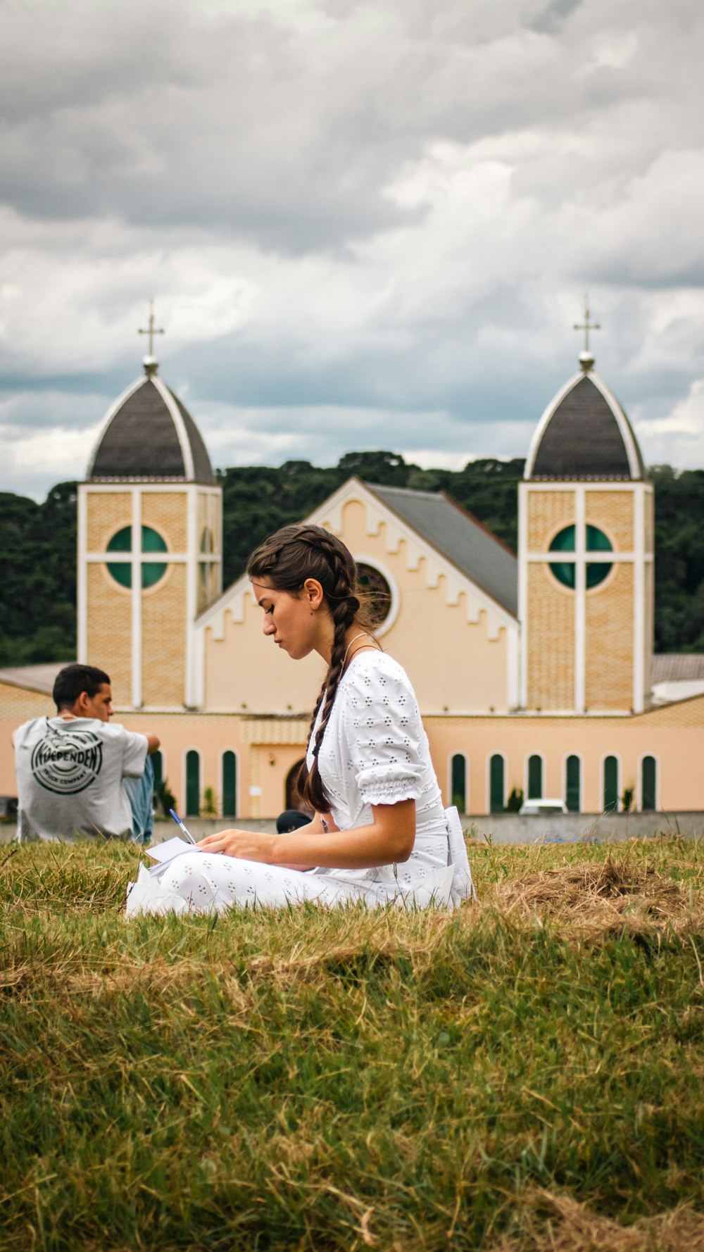 a woman sitting on the ground in front of a church