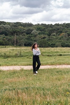 a woman standing in a field with a kite in the air