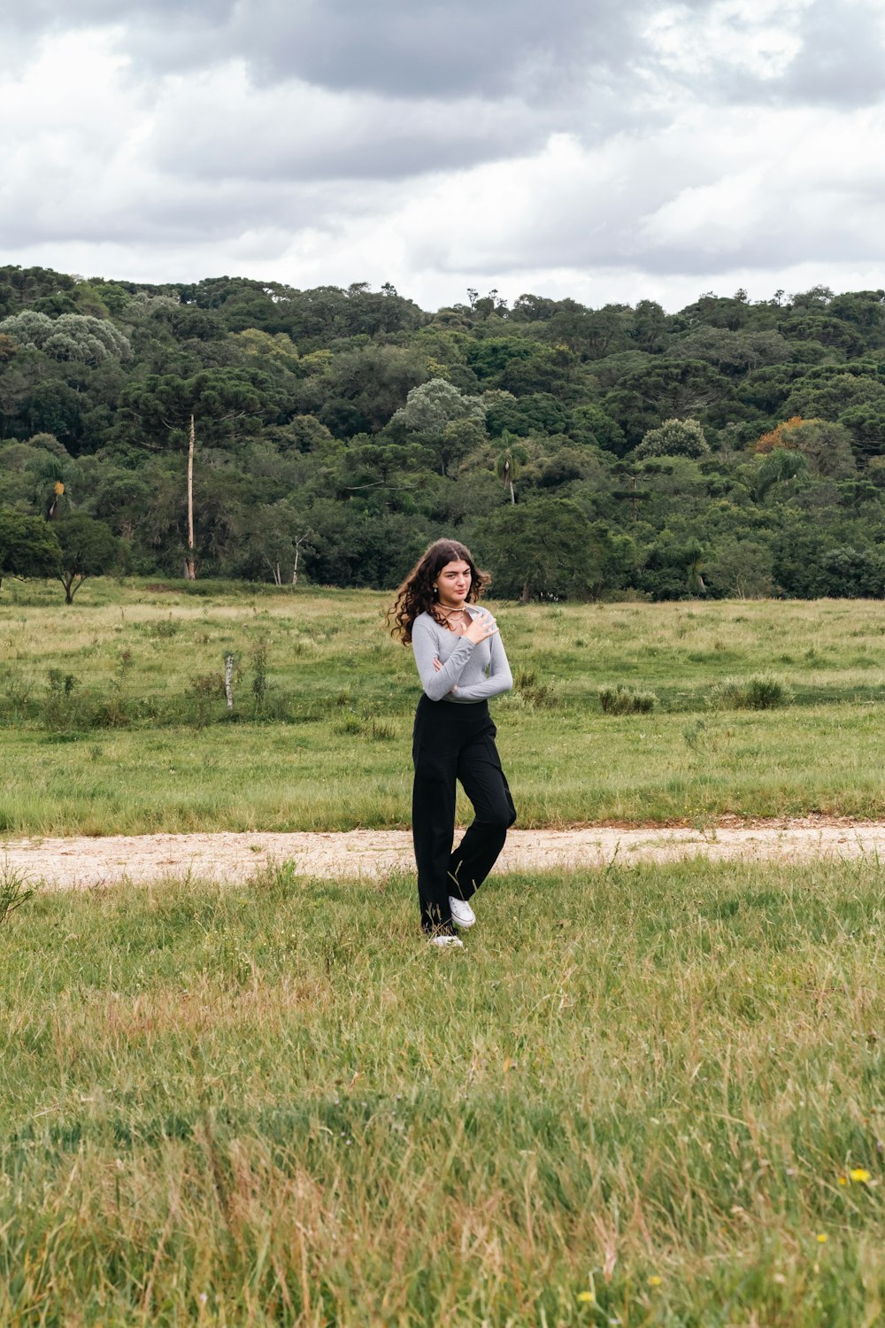 a woman standing in a field with a kite in the air