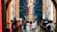 Individuals are kneeling in prayer inside a church. A large depiction of Jesus with a radiant halo is present in the background above the altar. The church interior features ornate designs and warm lighting. The congregation is facing the altar and appears to be engaged in a solemn religious ritual.