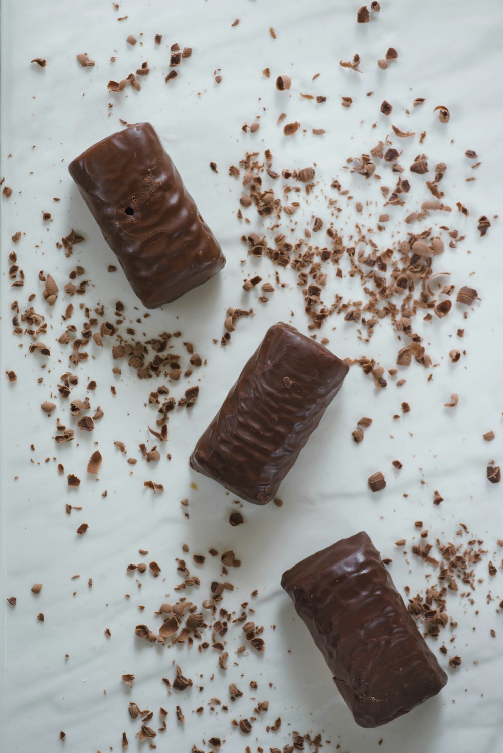 Tres trozos de chocolate sobre una superficie blanca