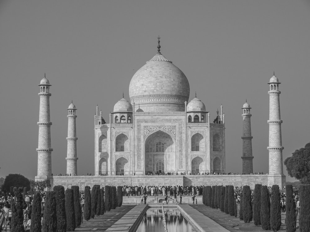 a black and white photo of a building with a fountain in front of it