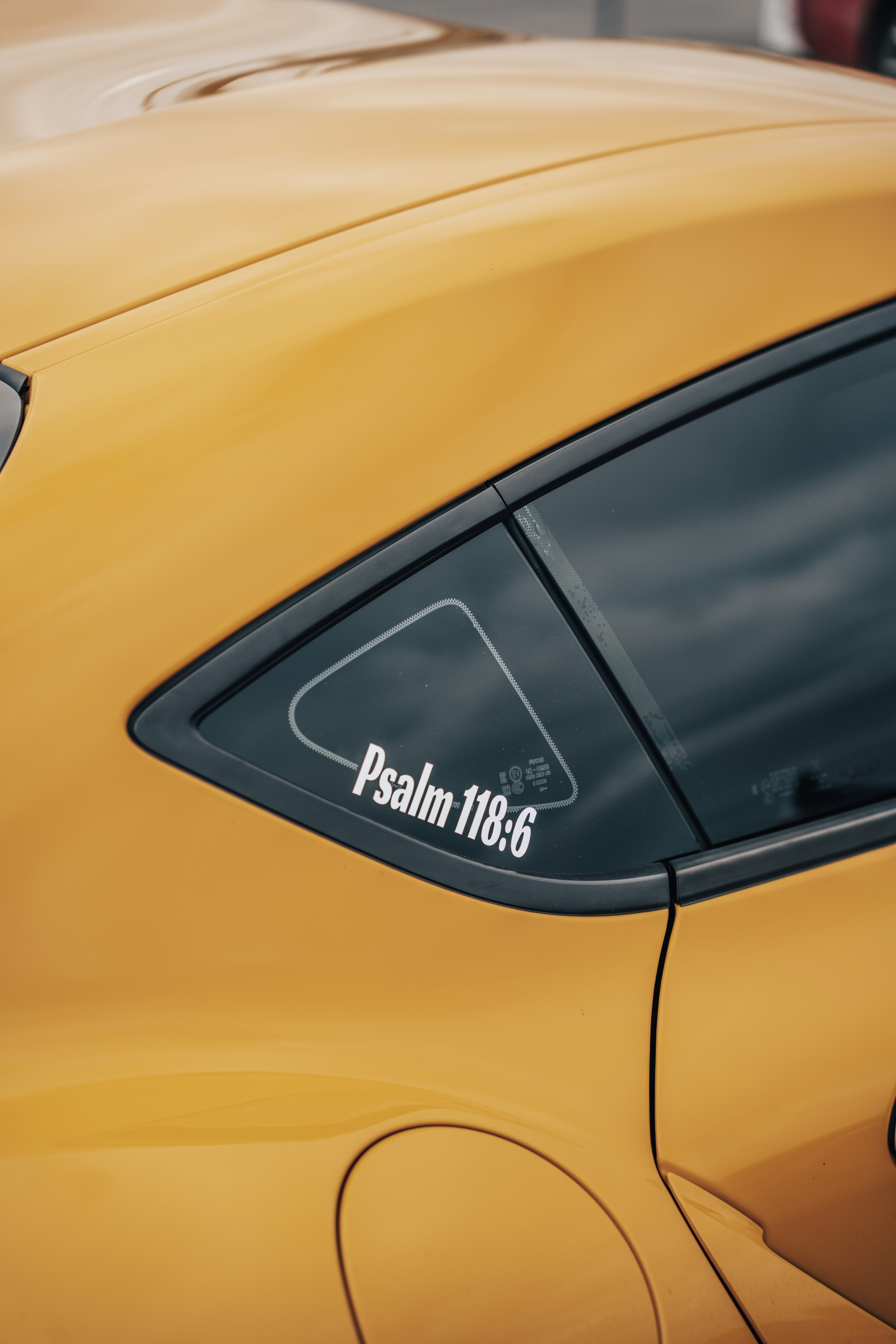 a close up of a yellow car with a sticker on it