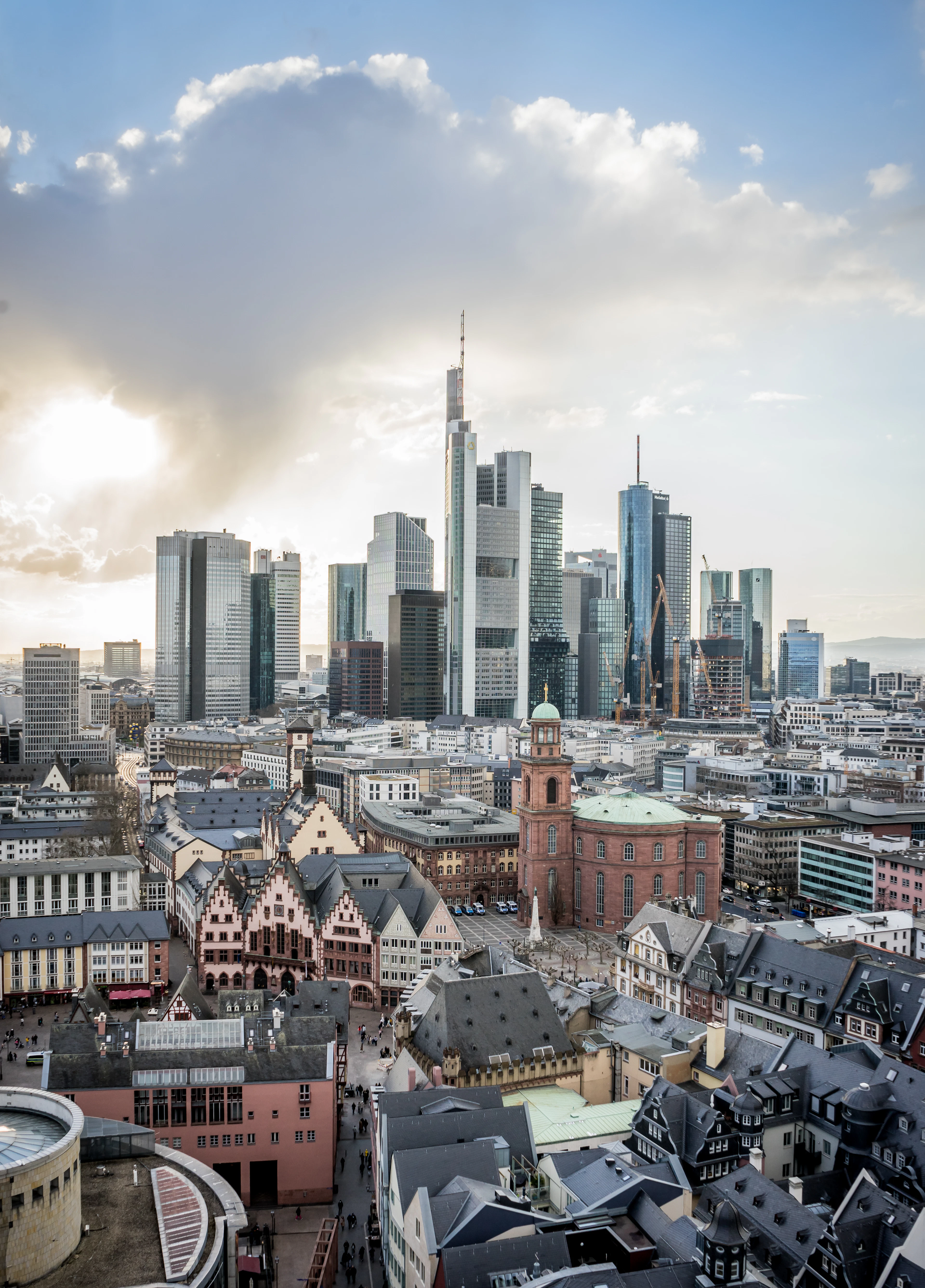 Frankfurt from above, glass towers rising directly behind the gabled roofs and church spires of the old centre