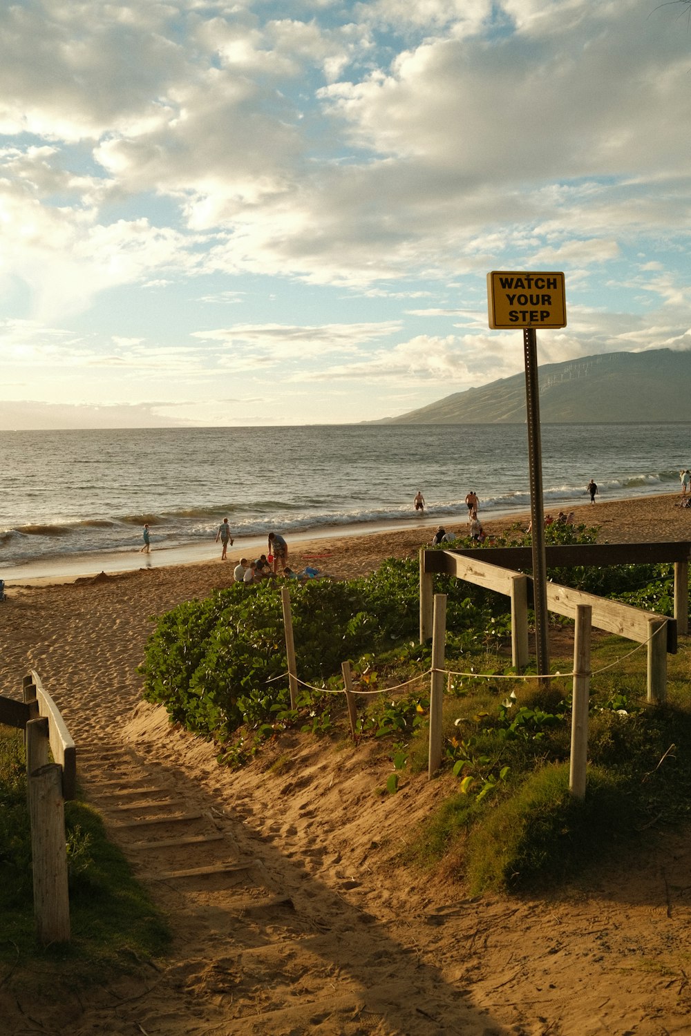 a sandy beach with steps leading to the ocean