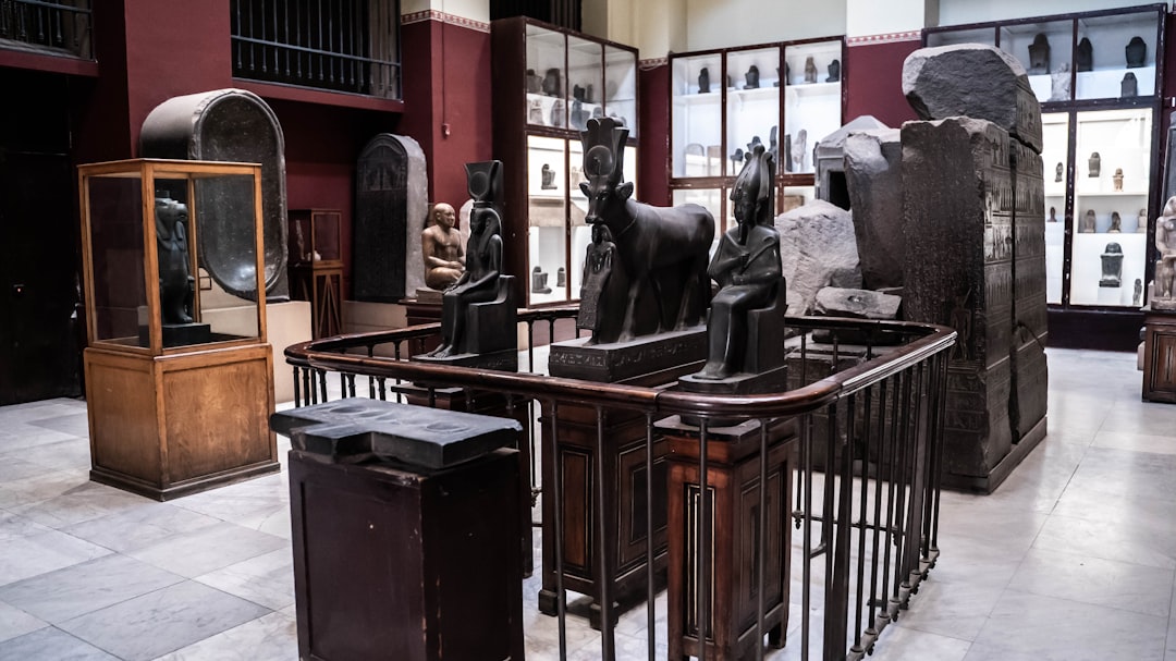 a room filled with lots of statues of animals, A collection of artefacts on display in the Grand Egyptian Museum