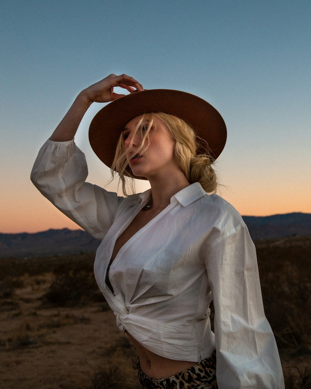 a woman wearing a hat in the desert