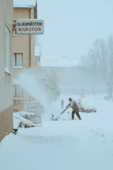 a man uses a snow blower to clear the snow