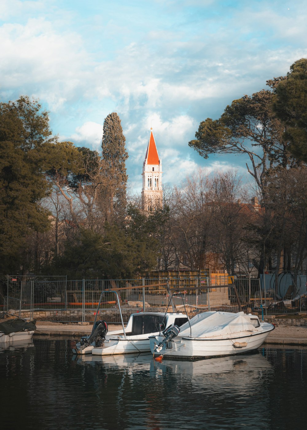 a white boat in the water with a church steeple in the background