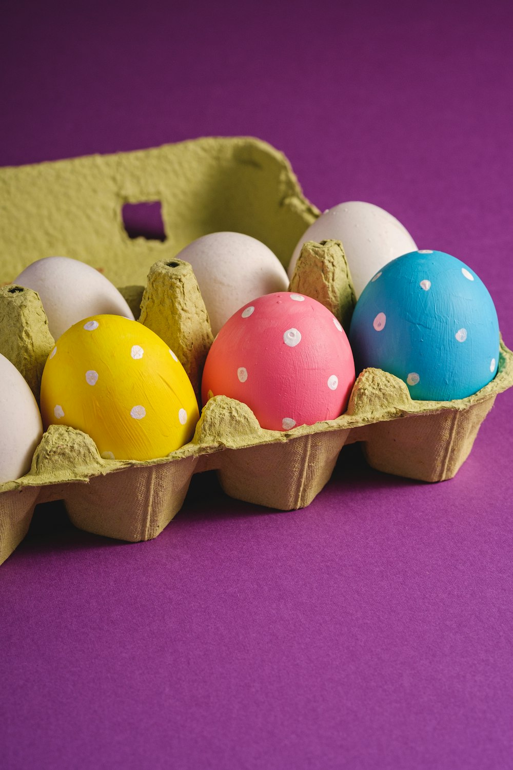 a carton of eggs on a purple background