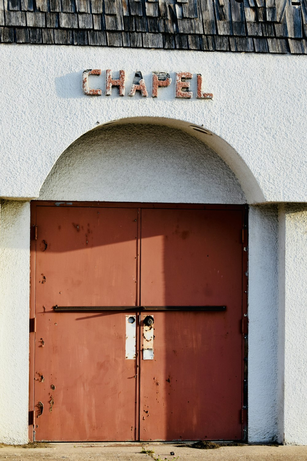 a red door is open in front of a white building