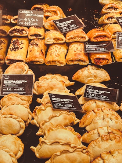Assortment of frozen empanadas, lehmeyun, and focaccias arranged on a tray.