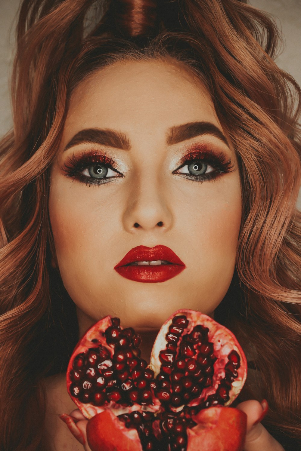 a woman holding a pomegranate in her hands