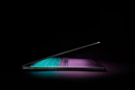 Close-up of sleek laptops with glowing screens set against a cheerful yellow backdrop.