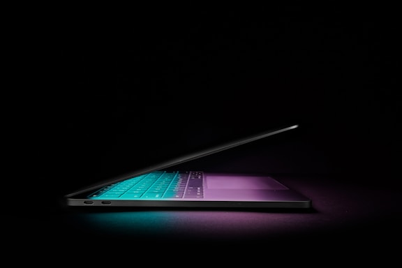 A sleek dark-themed contact form interface glowing softly on a modern laptop screen.