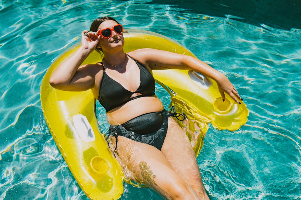 a woman in a bikini floating on an inflatable raft