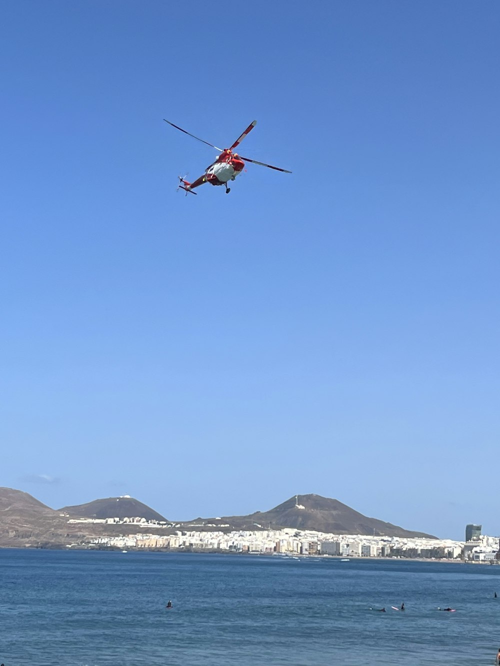 a helicopter flying over a body of water