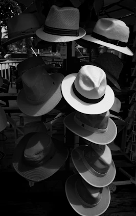 A sunlit beach scene featuring a variety of colorful Solara sun hats displayed on a wooden table.