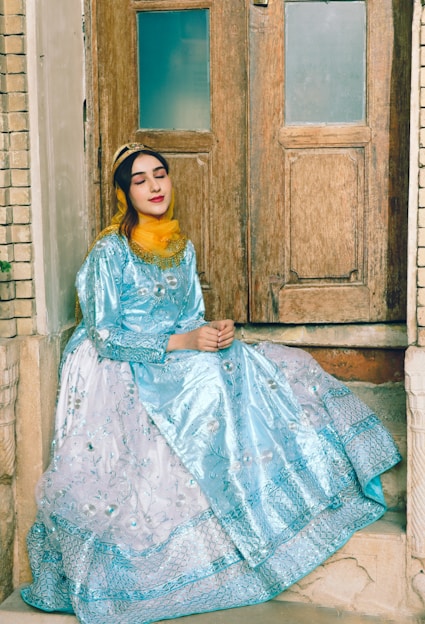 a woman in a blue dress sitting on a step