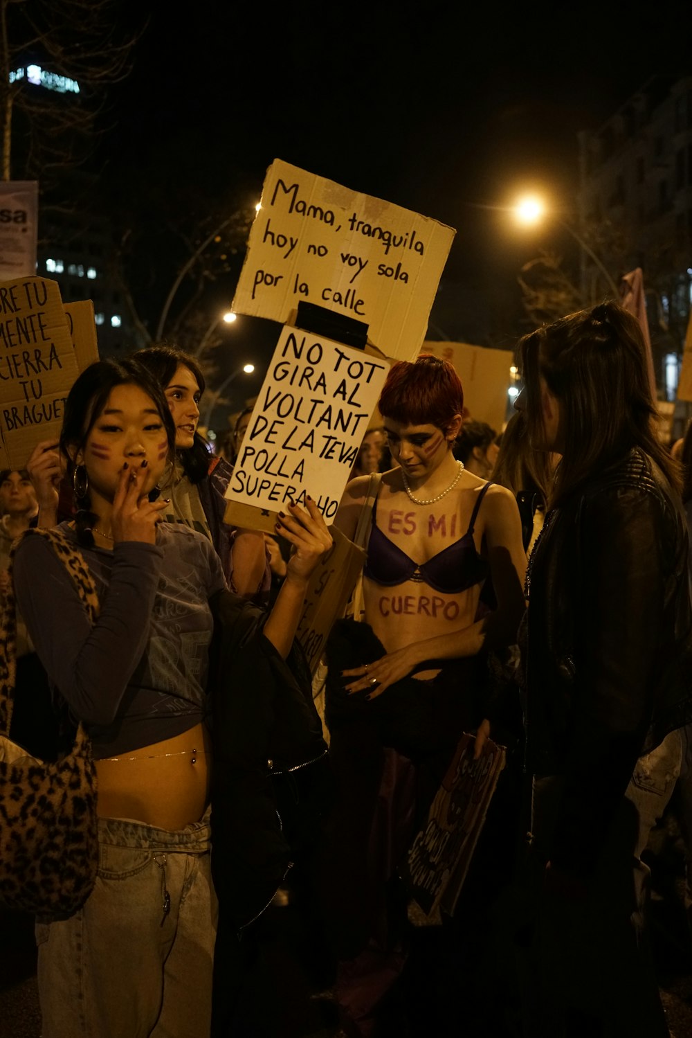 a group of people standing around each other holding signs