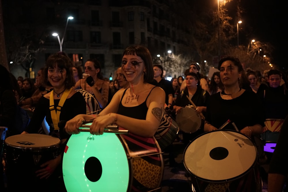 Un grupo de personas tocando la batería frente a una multitud