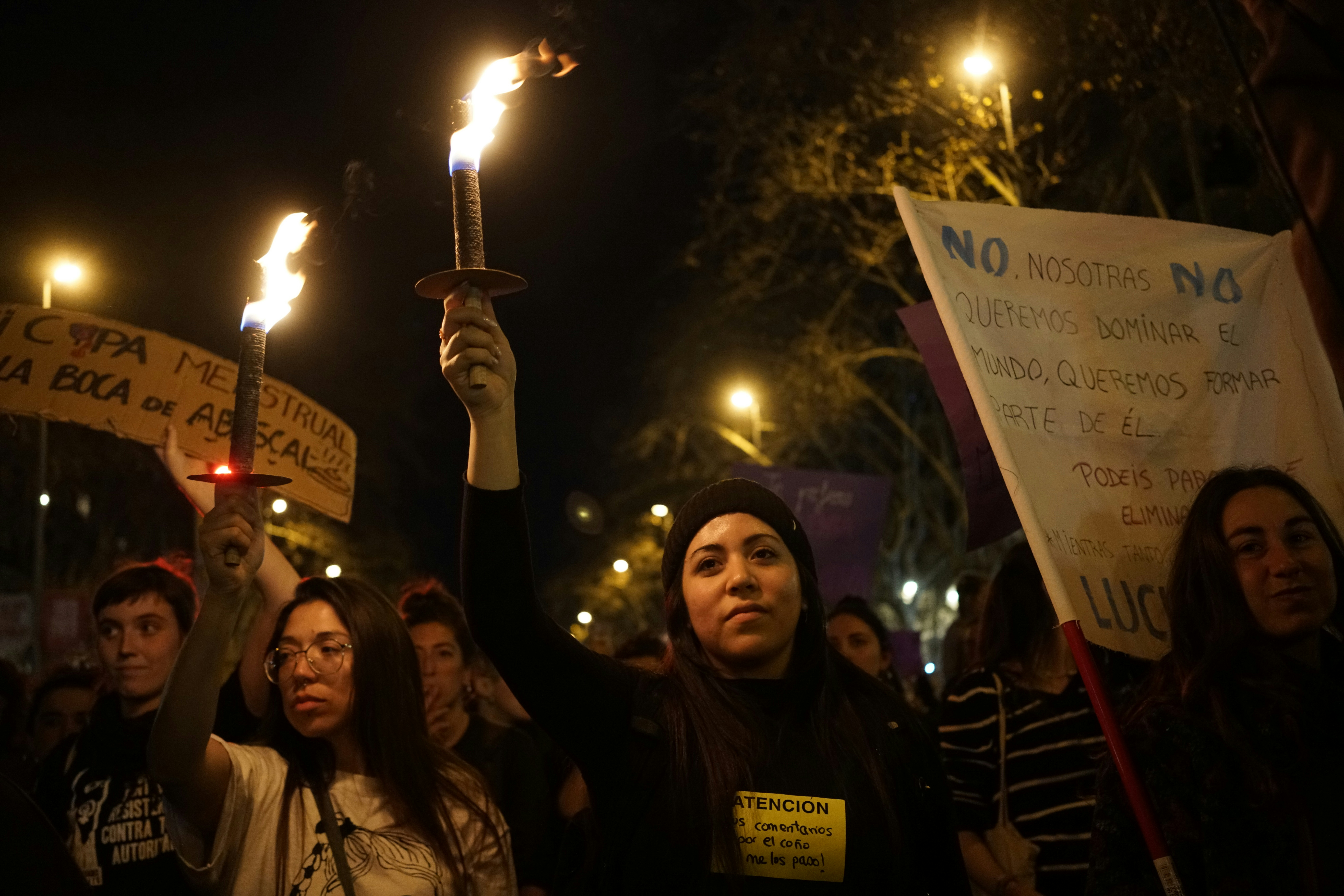 a group of people holding up signs and torches